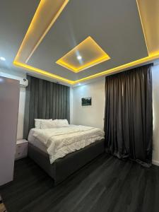 a bedroom with a large bed with a ceiling at EIMACK APARTMENT Service in Asaba