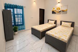 a bedroom with two beds in a room at Homies Homestay Boys Hostel in Kurukshetra