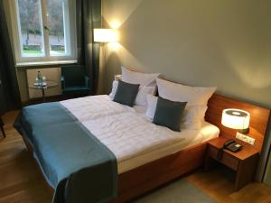 ein Schlafzimmer mit einem großen Bett mit weißer Bettwäsche und Kissen in der Unterkunft Hotel Schloss Rabenstein in Chemnitz