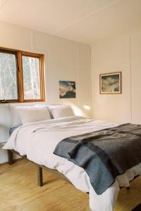 a white bedroom with a large bed in it at Skogstead Cabin in the boreal forest in Fairbanks