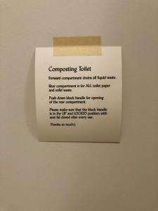 a sign on a wall that sayscompromising toilet feared government clinks all legal at Skogstead Cabin in the boreal forest in Fairbanks