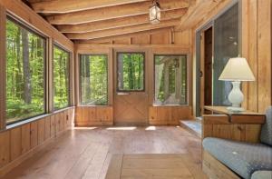 a living room with wooden walls and a door with windows at STARGAZER SHORES LIMIT 8 villa in Bridgton