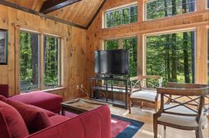 a living room with a tv in a cabin at STARGAZER SHORES LIMIT 8 villa in Bridgton +24 photos
