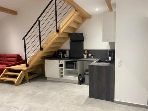 a kitchen with a staircase and a red couch at Alata Appartement T3 in Alata