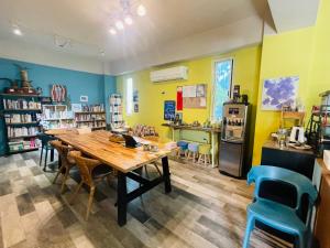 a library with a table and chairs and a refrigerator at Lanyu IGANG Hotel in Lanyu