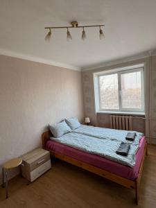 a bedroom with a bed and a window at 2 istabu dzīvoklis in Aizkraukle