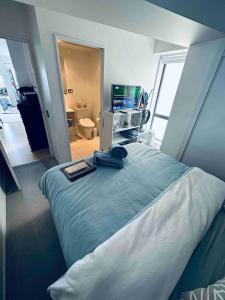 a bedroom with a bed with a television and a bathroom at Urba Residences in Auckland +33 photos