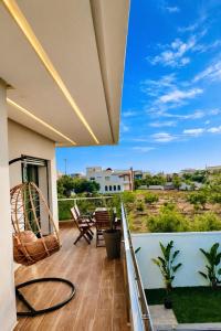 a balcony with a table and chairs and a view at Villa de luxe piscine chauffée & Jacuzzi & Petit déjeuner in Fez