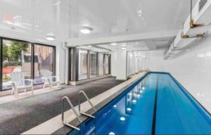 a large swimming pool with blue water in a house at Urba Residences in Auckland