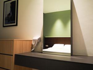 a mirror on a counter with a bed in a room at Roxy Beach Apartment, Sematan, Sarawak in Sematan +20 photos
