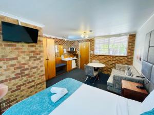 a room with a bed and a living room at Kinross Inn in Cooma