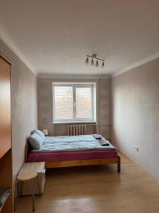 a bedroom with a bed and a window at 2 istabu dzīvoklis in Aizkraukle