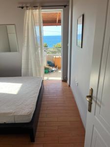 a bedroom with a bed and a view of the ocean at STUDIO WITH SEA VIEW - KYPARISSIA beach in Kyparissia