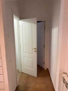 an empty hallway with a white door and a tile floor at B&B Ambra in Sarno +8 photos