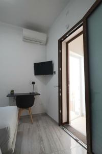 a room with a bed and a sliding glass door at Agorà di Favignana - Affittacamere Piazza Madrice in Favignana