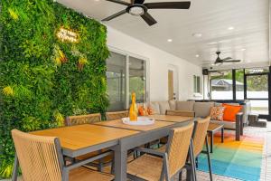 a dining room with a green wall with a table and chairs at The Mimosa House in Sarasota