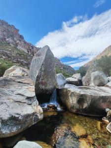 a stream of water between rocks in a mountain at Tranquility - Cabin nestled in the mountains in Worcester +5 photos