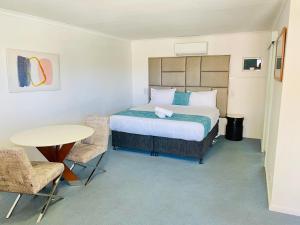 a bedroom with a bed and a table and chairs at Kinross Inn in Cooma +86 photos