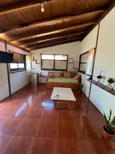 a living room with a bed and a wooden floor at L0st & Found House - Casa Bar in Puerto Iguazú