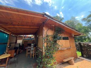 a wooden cabin with a patio with a table and chairs at L0st & Found House - Casa Bar in Puerto Iguazú