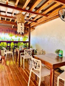 a dining room with wooden tables and white chairs at Panari Lodge El Nido in El Nido