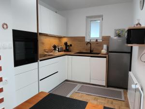 a small kitchen with white cabinets and a refrigerator at Apartma Gašper in Šentjur