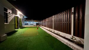 a dark hallway with a green floor in a building at Serene Private Villa Kangar in Kangar