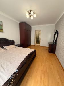 a bedroom with a bed and a wooden floor at Comfortable zone in Yerevan