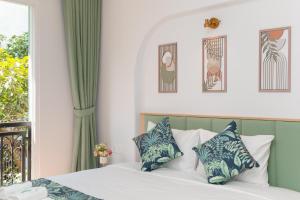 a bedroom with a bed with blue and white pillows at Casa Del Mar Hotel & Apartment - Sunset Town, Phu Quoc in Phú Quốc