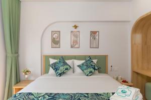 a bedroom with a bed with blue and white pillows at Casa Del Mar Hotel & Apartment - Sunset Town, Phu Quoc in Phú Quốc