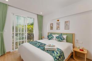 a bedroom with a large bed and a window at Casa Del Mar Hotel & Apartment - Sunset Town, Phu Quoc in Phú Quốc