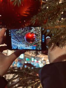 a person taking a picture of a christmas tree at Casa Ema Azuga in Azuga +14 photos