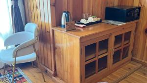 a wooden cabinet with a microwave and a chair at Apartment in Thimphu