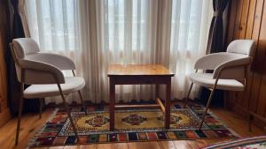 a room with two chairs and a table and a rug at Apartment in Thimphu