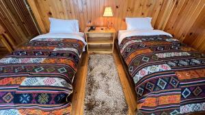two beds in a wooden room with a table at Apartment in Thimphu