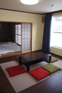 a room with a bed and a table and a window at Puffin House in Engaru