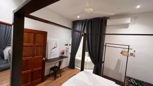 a bedroom with a bed and a desk and a window at Serene Private Villa Kangar in Kangar +11 photos