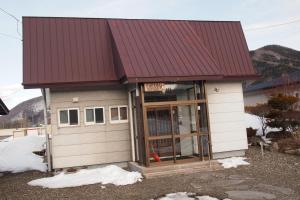 a small house with a red roof at Puffin House in Engaru