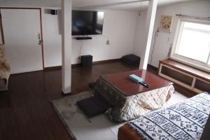 a room with a bed and a table and a television at Puffin House in Engaru