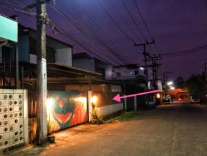 an empty street at night with a pink arrow at SpamHouse Ranong in Ban Bang Rin (1)