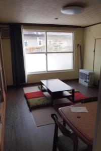 a living room with a table and a window at Puffin House in Engaru