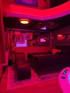 a bedroom with a bed and a red lighted room at Le 1920- Spa & Sauna privé- Love Room in Le Havre