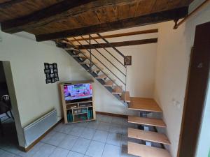 a staircase in a living room with a tv at maison volet rouge in Devay