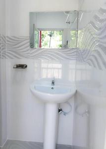 a white bathroom with a sink and a mirror at YK House Midigama in Midigama East +10 photos