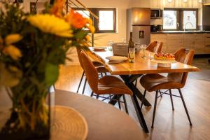 a dining table with chairs and a vase of flowers at Fank'House in Guémar