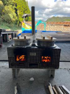 an outdoor oven with fire inside of it at Ryuo Field in Kikuchi