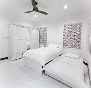 a bedroom with two beds and a ceiling fan at Bluesky Villa Bang Sare in Bang Sare +15 photos