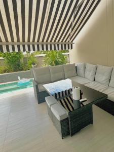 a living room with a couch and a table and a pool at Bluesky Villa Bang Sare in Bang Sare