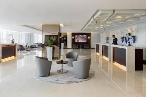 a living room filled with furniture and a tv at Jumeira Rotana – Dubai in Dubai