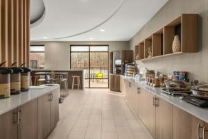 a large kitchen with wooden cabinets and a table at SpringHill Suites by Marriott Morgantown in Morgantown